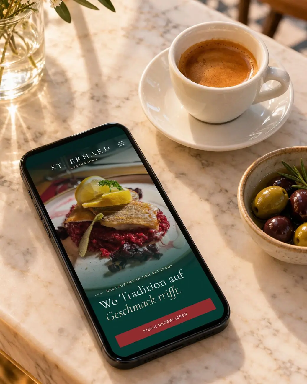 Smartphone mit der Website des Restaurant St. Erhard auf einem Marmortresen